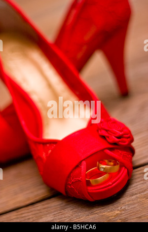 Dieses Foto zeigt ein paar rote Womans Schuhe für eine Hochzeit mit der Hochzeit Ringe in die Schuhe Stockfoto