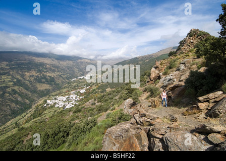 Wanderer zu Fuß entlang der Strecke mit Dörfern Bubion (unten) und Capileira in der Sierra Nevada Bergkette Alpujarra Spanien Stockfoto