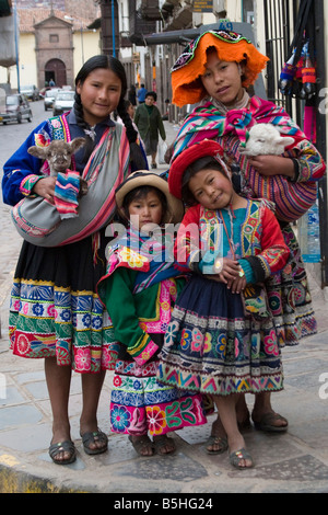 vier Peruaner-Mädchen in traditioneller Kleidung auf den Straßen von Cusco, Peru Stockfoto