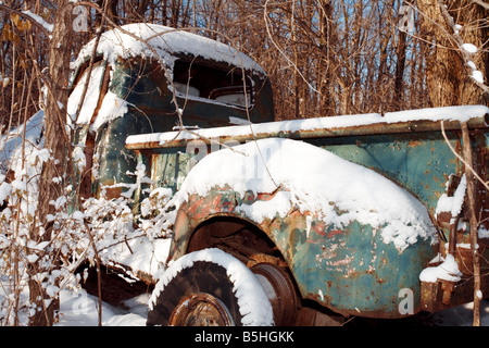 Ein alter verrosteter LKW unter einem Haufen Neuschnee. Stockfoto