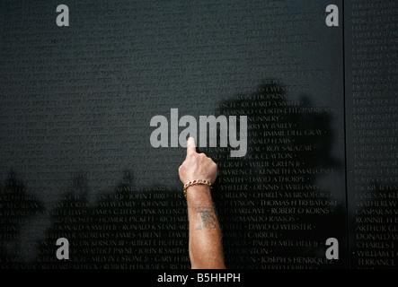Ein Mann zeigt auf einen Namen auf dem Vietnam-Krieg-Denkmal in Washington, D.C. Stockfoto