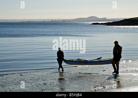 dh Paar Kajak Kanus WASSERSPORT KAJAKFAHREN Großbritannien SCHOTTLAND zwei Frau Am Strand mit Kanu zum Wasser Rand Meer Sport 2 Menschen Stockfoto