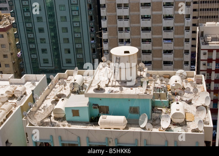 Durcheinander von Satelliten TV Gerichte auf der Oberseite eine alte Wohnung Block in Abu Dhabi Stockfoto