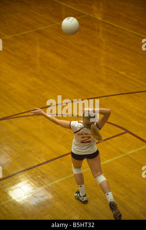 Service von High-School-Volleyball-Spieler Stockfoto