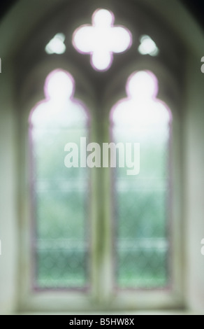 Impressionistische frühen englischen Gotik Diamant verbleit einfache Fenster mit lila Fransen mit Rasen und Sträuchern außerhalb Stockfoto