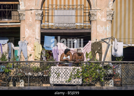 Ein paar schaut vom Balkon einer verfallenden aber bunte Haus im zentralen Havanna, Kuba Stockfoto