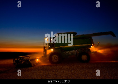 Ein Mähdrescher erntet Weizen auf den Hügeln der Palouse Region Washington in der frühen Abenddämmerung nach Sonnenuntergang Stockfoto