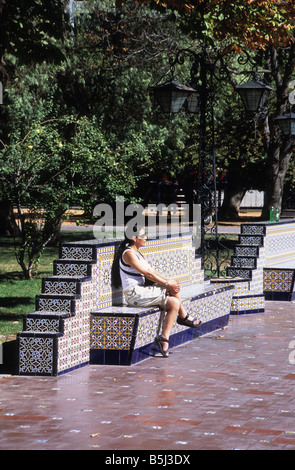 Hispanisches Mädchen sitzt auf einer kunstvoll verzierten Parkbank in Plaza España, Mendoza, Argentinien Stockfoto