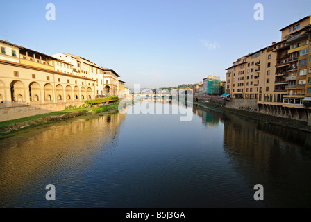 FLORENZ, Italien – der Fluss Arno fließt ruhig durch das Herz von Florenz, sein olivgrünes Wasser spiegelt die historische Architektur der Stadt wider. Berühmte Brücken, einschließlich der berühmten Ponte Vecchio, überspannen den Fluss und verbinden die beiden Hälften dieses Renaissanceschmucks unter der warmen toskanischen Sonne. Stockfoto