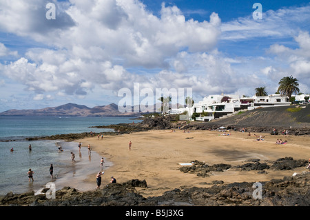 dh Strand PUERTO DEL CARMEN LANZAROTE Sonnenanbeter auf kleine Lava Stein Sand Strand Stockfoto