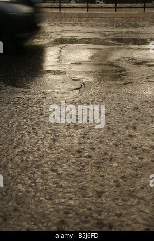 viel Regen Tropfen fallen in Wasser Pfütze auf Straße Stockfoto