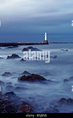 Die südlichen Wellenbrecher und der Leuchtturm am Eingang zum Hafen von Aberdeen, Schottland, in der Dämmerung zu sehen. Stockfoto