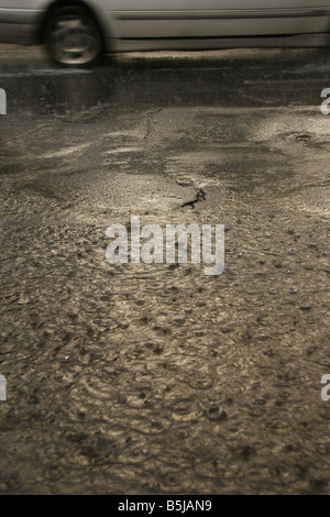 viel Regen Tropfen fallen in Wasser Pfütze auf Straße Stockfoto