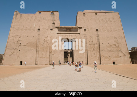 Touristen zu Fuß außerhalb Edfu alten ägyptischen Tempel, der dem Falkengott Horus geweiht, in ptolemäischer Zeit zwischen 237 und 57 v. Chr., Ägypten gebaut Stockfoto