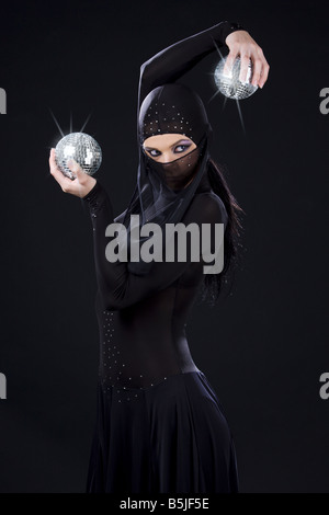 Partei-Tänzerin in Ninja-Kleid mit Disco-Kugeln Stockfoto