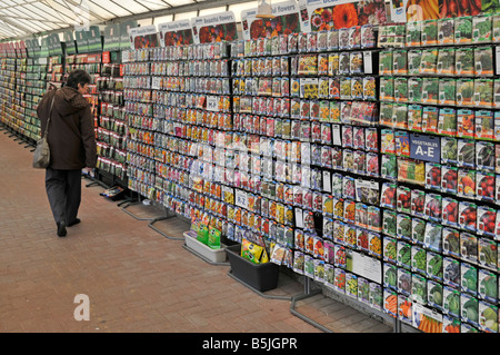 Model hat eine Frau auf den Markt gebracht, die im Gartencenter Essex England UK Saatgutpackungen einkauft Stockfoto