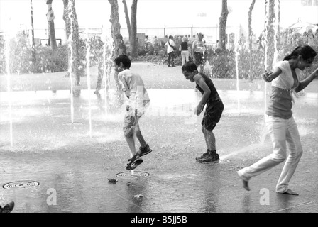 Kinder spielen in den kühlen Brunnen am Battery Park an einem heißen Sommertag in New York Stockfoto