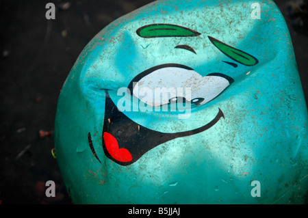 A semi-deflationiert Smiley Kugel schwimmt in einem Rock Pool gespült. Stockfoto