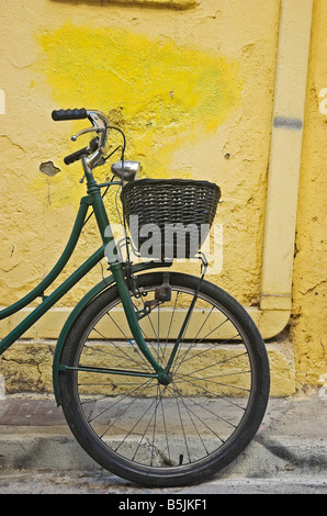 Fahrrad mit Korb Wand gelehnt Stockfoto