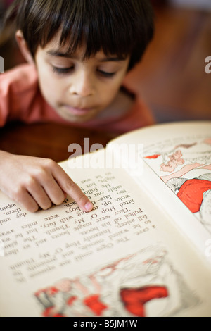 Sechs Jahre alt zeigt junge auf Worte im Buch, als er erfährt, zu lesen Stockfoto