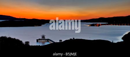 Ein lebhafter Sonnenuntergang über Aultbea und der Isle of Ewe, mit dem NATO-Tanksteg, der vom Aussichtspunkt entlang der A832 in Wester Ross, Schottland, sichtbar ist. Stockfoto