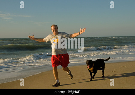 Mann mit Hund am Strand Stockfoto