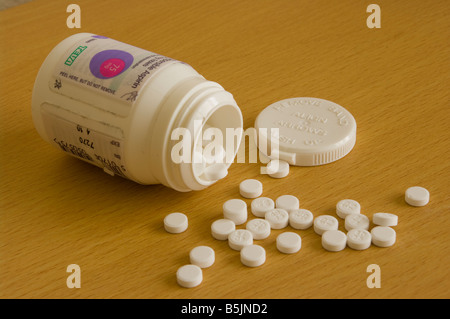 Öffnen der Flasche Aspirin Tabletten auf Its mit Tabletten verschüttet auf A Beistelltisch Stockfoto