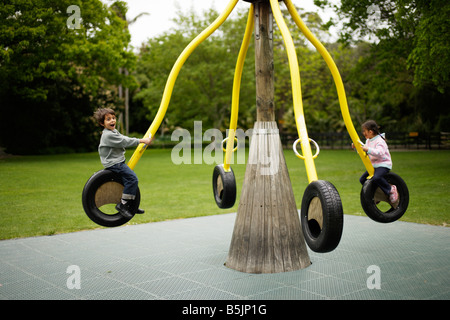 Sechs Jahre alter Junge spielt auf dem Spielplatz mit seiner fünf Jahre alten Schwester Stockfoto