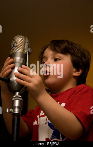 Kleiner Junge singt ein altes Mikrofon Stockfoto