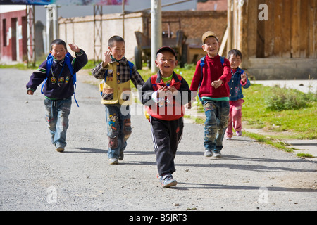 Fünf glückliche junge Jungs kommen aus der Schule auf einer Straße im Mounigou-Tal in der Nähe von Songpan in Sichuan Provinz China JMH3484 Stockfoto