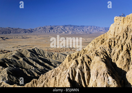 Wanderer an Stelle der Schriftarten in Borrego Badlands mit Vallecito Berge in Ferne an der Anza Borrego Desert Staatspark Kalifornien USA Stockfoto