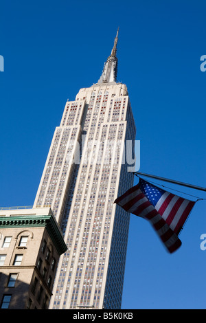 Das Empire State Building mit Sternen und Streifen fliegen im Wind, Fifth Avenue New York City USA Stockfoto