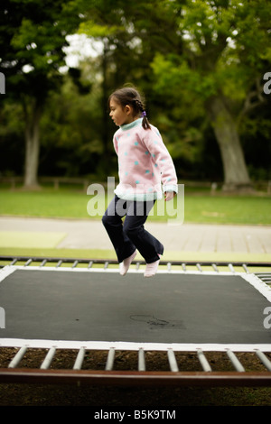 Fünf Jahre altes Mädchen auf einem Trampolin springen Stockfoto