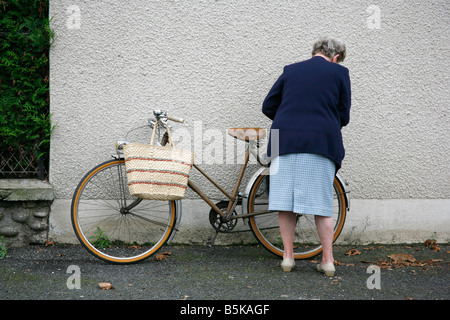 Alte Dame mit Fahrrad in Argentat Markt Correze Frankreich Stockfoto