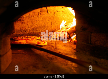 Pizza backen im Backofen offen Brennholz Stockfoto