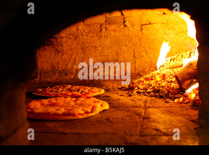 Pizza backen im Backofen offen Brennholz Stockfoto