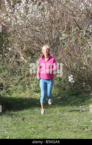 Junge blonde Frau im Freien. Joggen in der Landschaft. Stockfoto