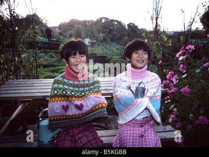 Chinesen zwei Mädchen lachend und kichernd in eine Zuteilung. Stockfoto