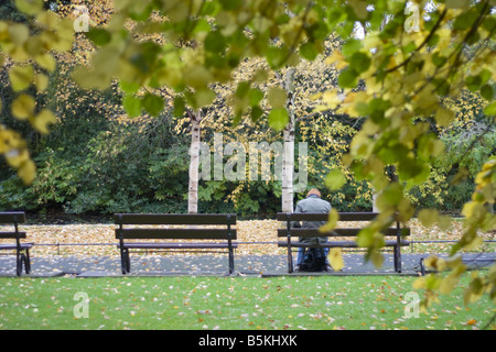 Einsamer Mann sitzen auf einer Bank in einem park Stockfoto