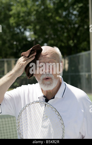 Ein heiß und müde senior Mann wischte seine Stirn nach einem Tennismatch Stockfoto