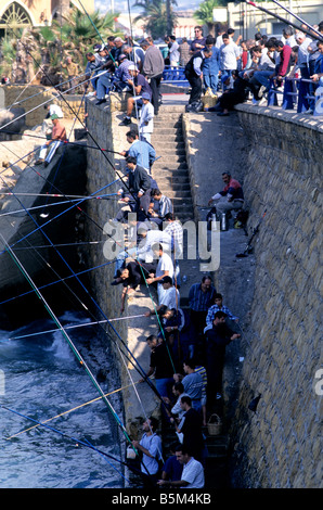 Fischer mit ihren Dutzenden werfen ihre Linien in das Meer von den Wänden der Corniche von Beirut im Libanon. Stockfoto