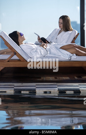 Zwei Frauen am Pool faulenzen. Stockfoto