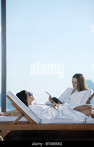 Zwei Frauen am Pool faulenzen. Stockfoto