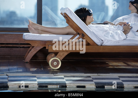 Zwei Frauen am Pool faulenzen. Stockfoto