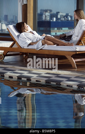 Zwei Frauen am Pool faulenzen. Stockfoto