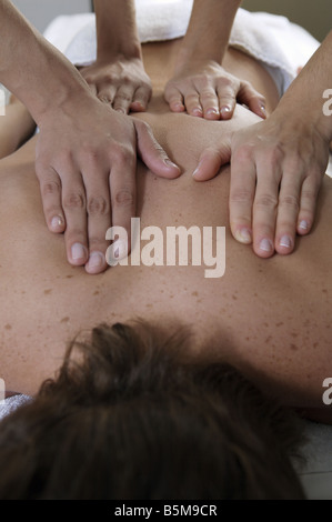 Man erhält eine Massage von zwei Frauen. Stockfoto