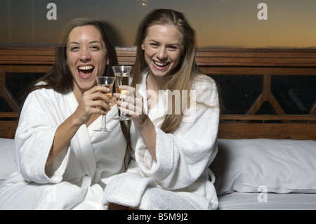 Zwei Frauen in ihren Roben, Champagner trinken. Stockfoto