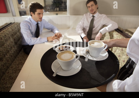 Kellnerin serviert Kaffee. Stockfoto