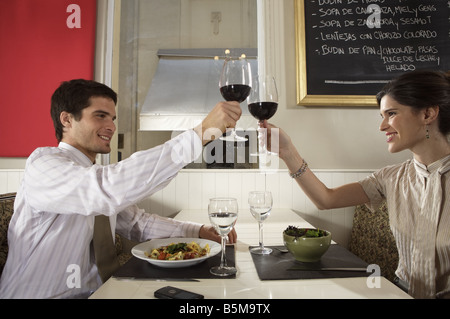 Ein paar mit einem Toast beim Abendessen. Stockfoto