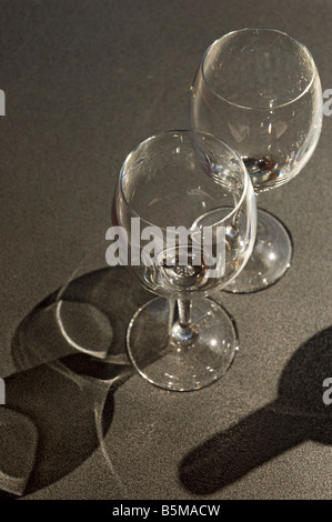 Zwei leere Gläser und eine Flasche Wein auf einem Tisch Stockfoto